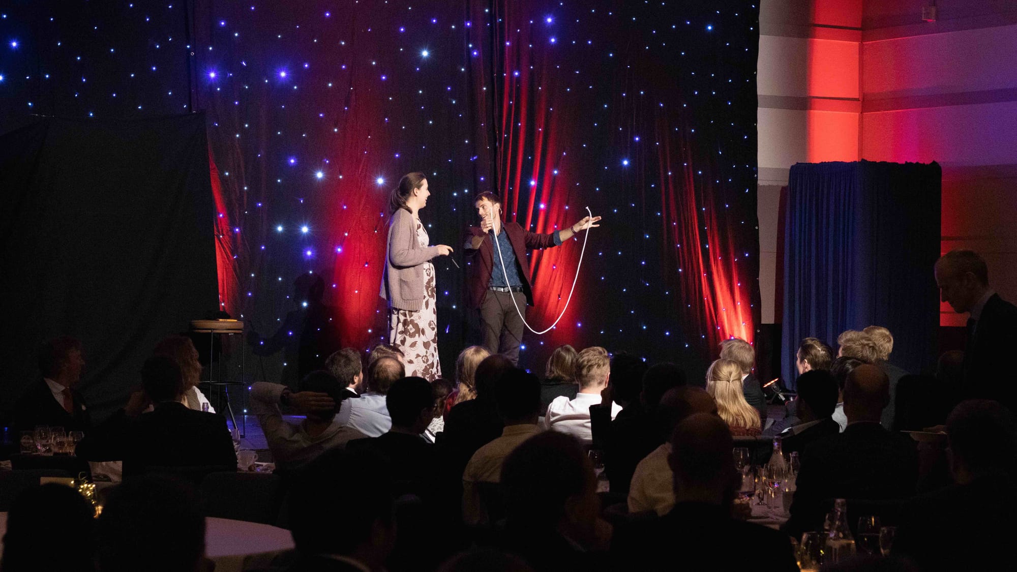 Hans Grane performing rope magic trick at corporate event on stage in norway