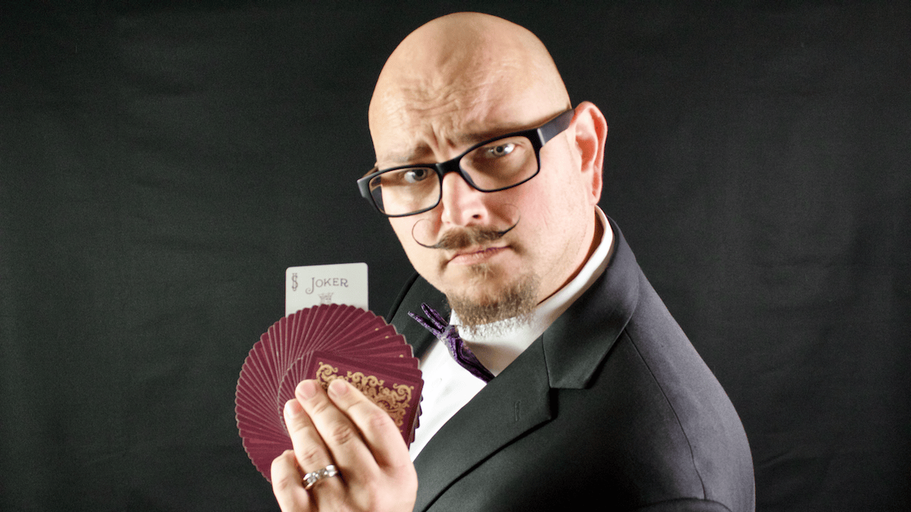 Studio headshot of Coral Springs magician Joseph DiPietro holding a fanned deck of cards