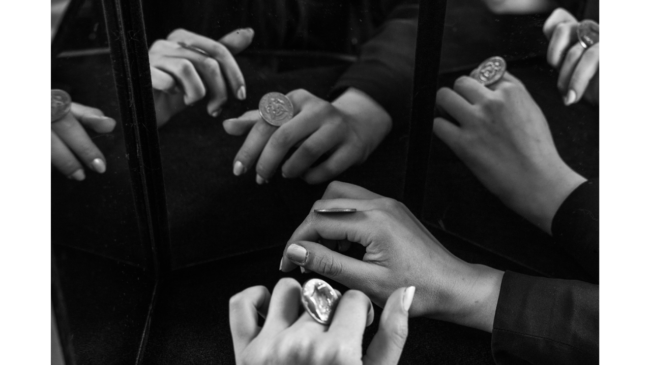 Rachel wax photographed practicing sleight of hand with a coin