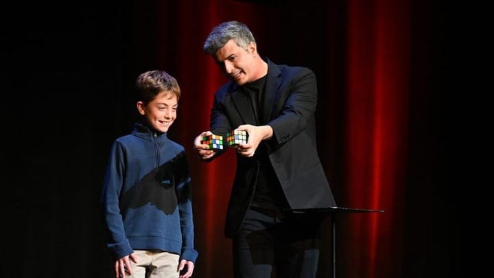 Magician Asi Wind on stage in London with Rubik's cubes